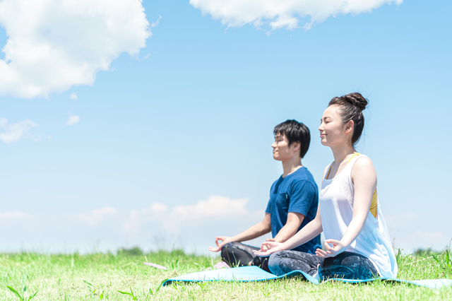 青空の下で瞑想する男女